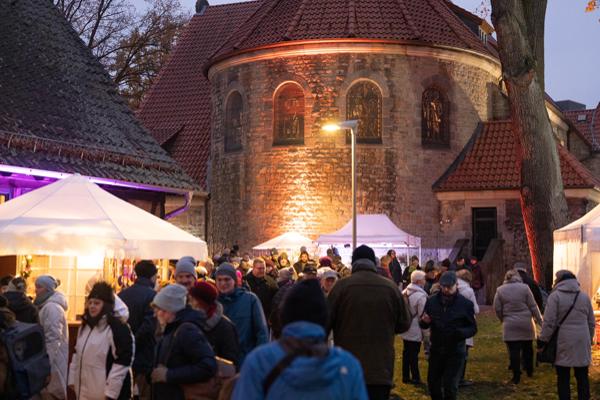  Weihnachtsmarkt Menschen strömen durch die Gänge vor der Kirche